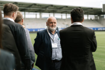 Männer mit Anzügen stehen auf dem Fußballfeld